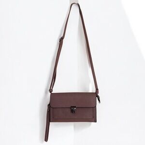 Isabelle Cambria Crossbody bag- mauve color with a silver push lock closure.